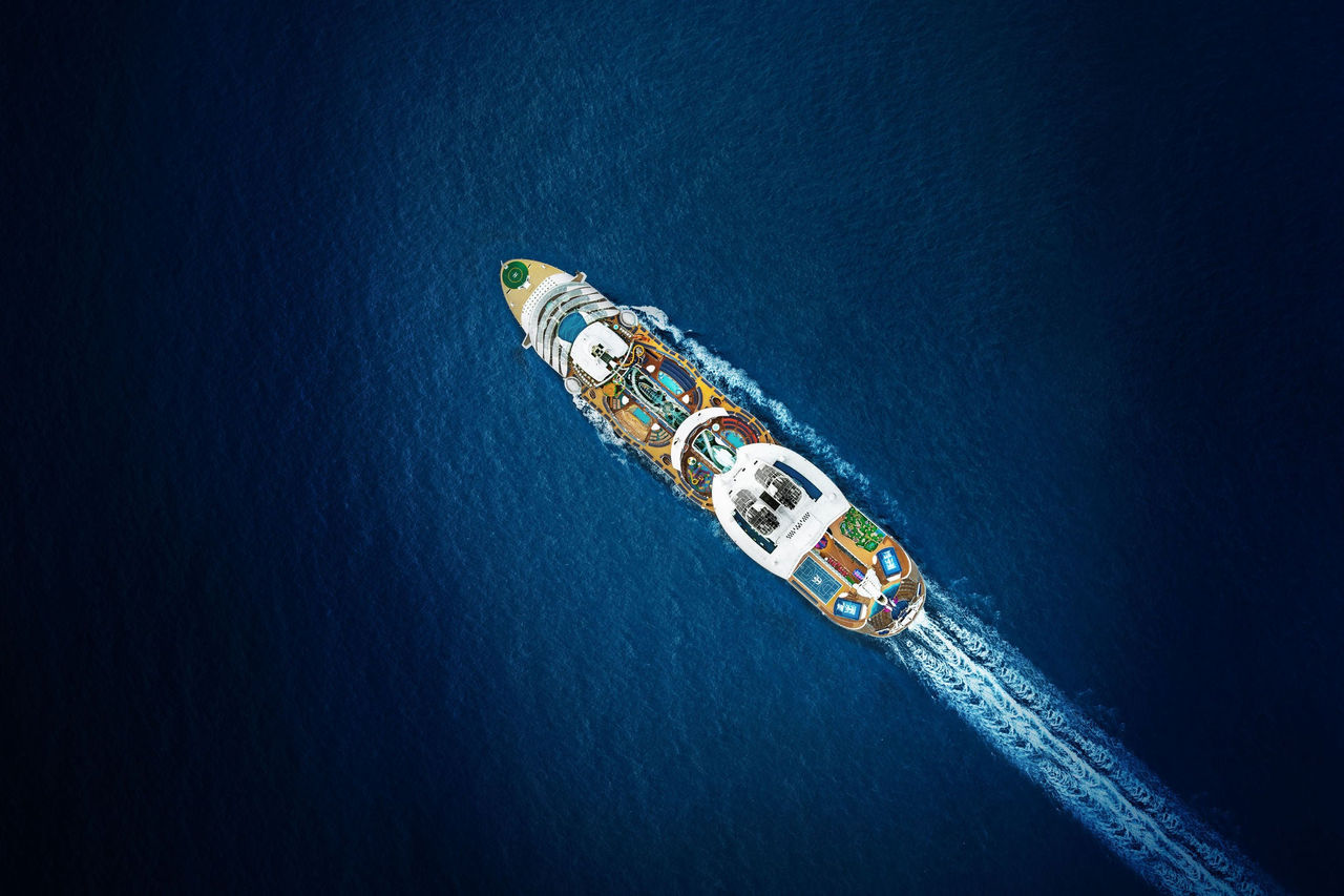 Aerial shot of a cruise ship moving across the ocean