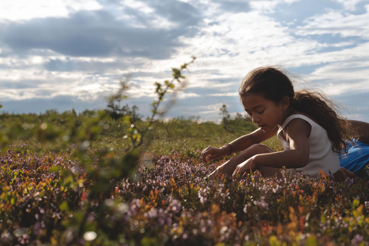 Little girl sat in field of flowers Little girl sat in field of flowers